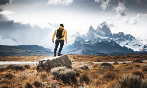 An individual is hiking toward mountains.