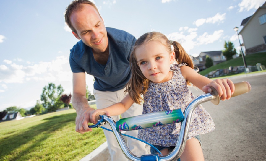 father and daughter riding bike