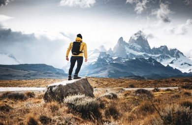 hiker in yellow jacket viewing landscape