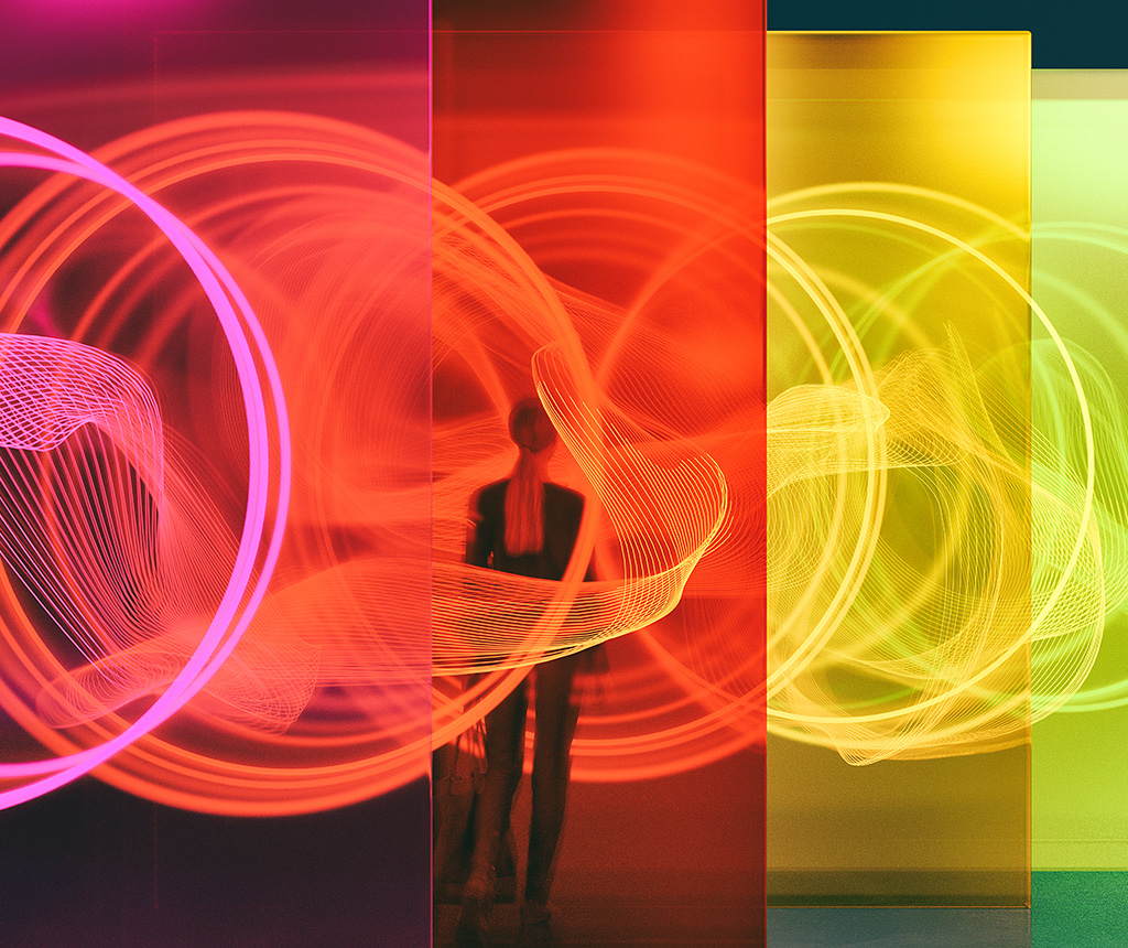 Woman facing a row of colored panels with abstract neon rings and swirls.